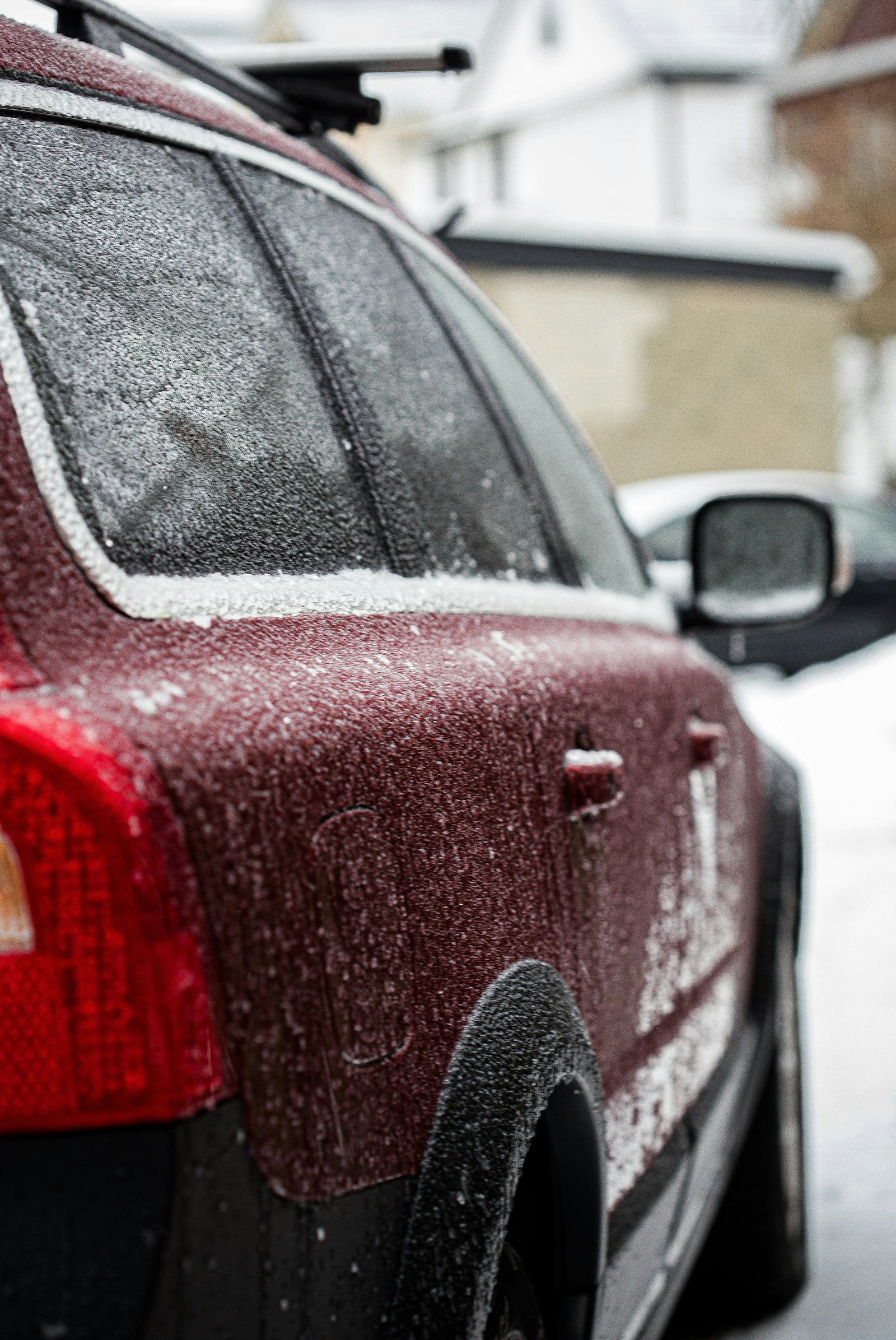 Red car covered in snow in winter